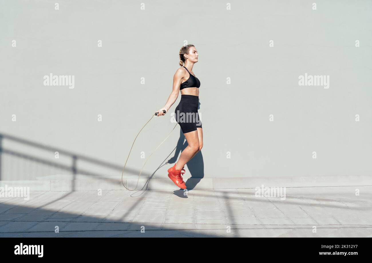 Mujer negra satisfecha más tamaño en ropa deportiva con cuerda para saltar  lista para entrenar sobre fondo rosa, espacio libre Fotografía de stock -  Alamy