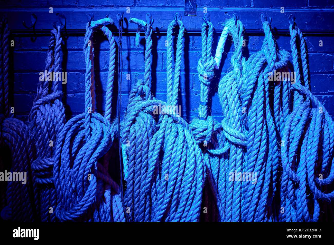 Cuerdas entre bastidores en el teatro en luz azul Foto de stock