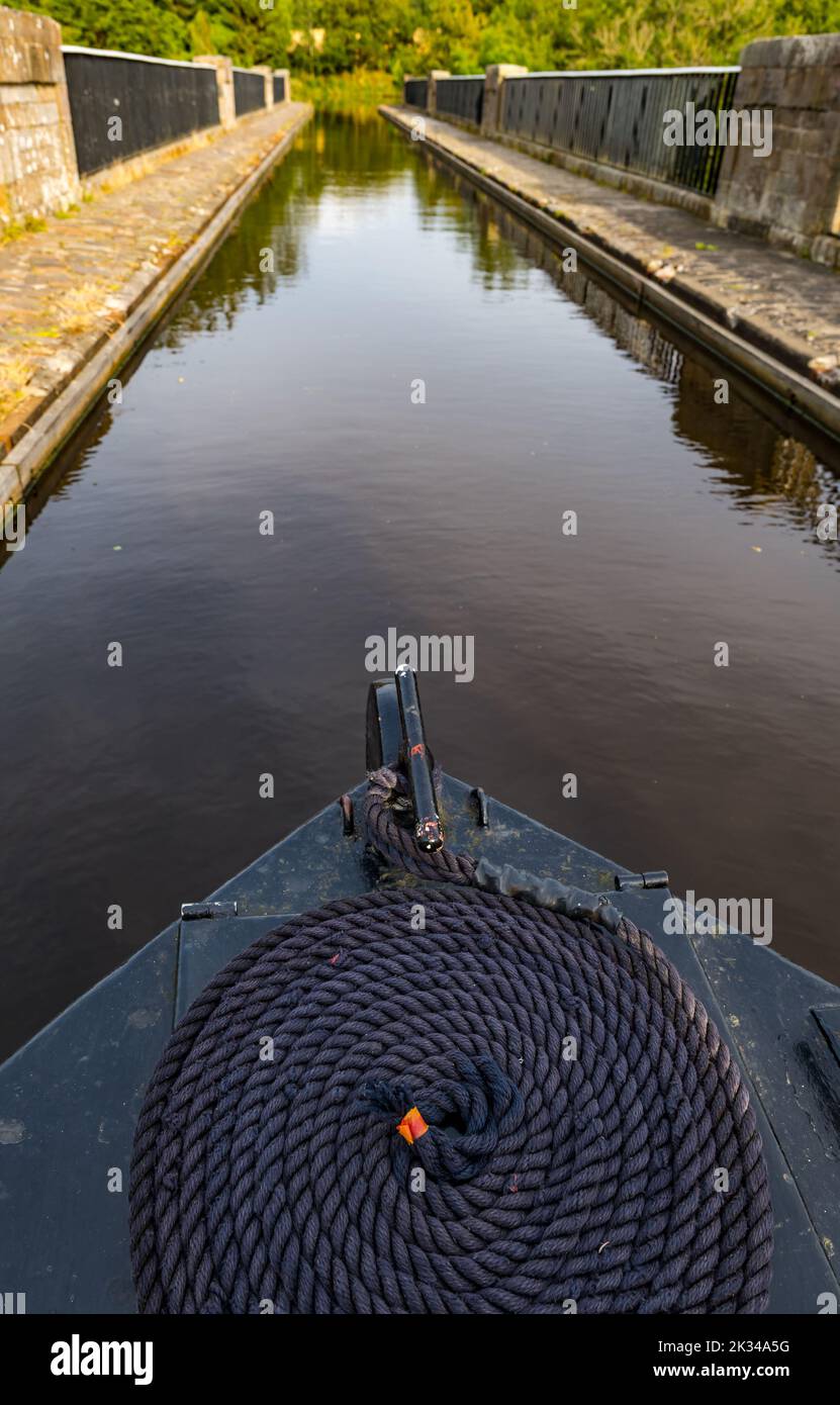 Vista desde proa de una estrecha barcaza con cuerda enrollada en el canal Union en el acueducto Almond, Escocia, Reino Unido Foto de stock