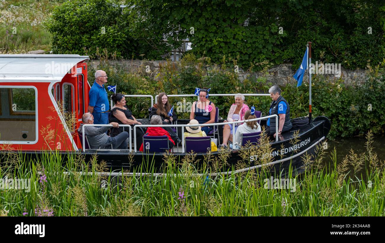 Personas en una excursión de barco flotante en barcazas por el canal para celebrar un cumpleaños número 50th en Union Canal, Escocia, Reino Unido Foto de stock