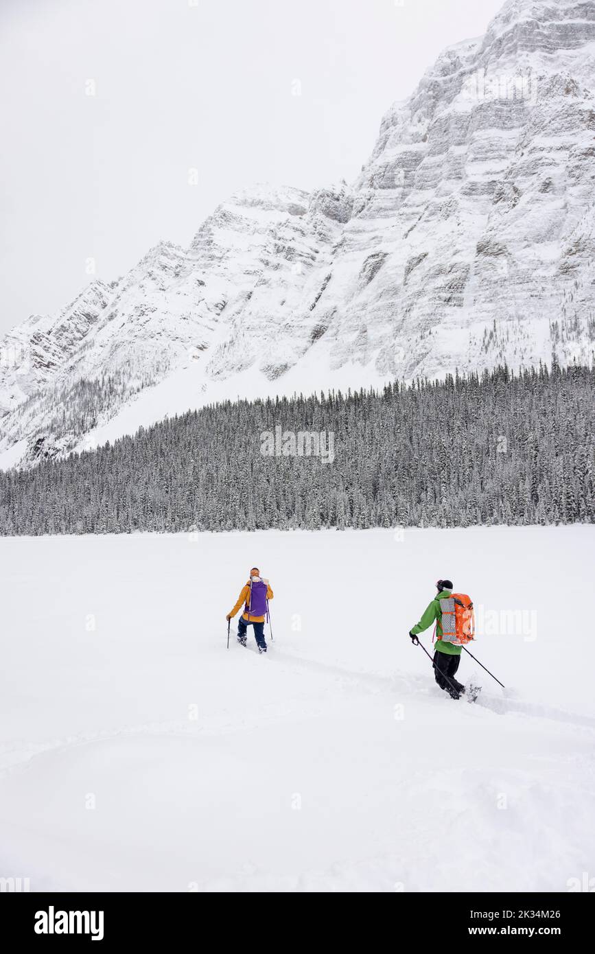 Amigos esquí de fondo debajo de las majestuosas Montañas Rocosas canadienses Foto de stock