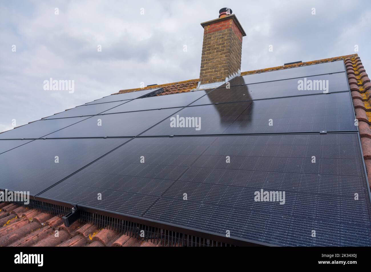 Paneles solares fotovoltaicos en el techo de una casa en el Reino Unido Foto de stock