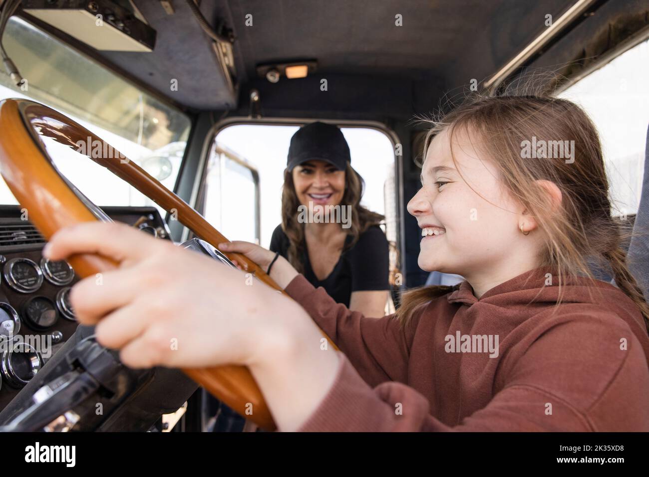 Chica feliz pretendiendo conducir semi camión Foto de stock
