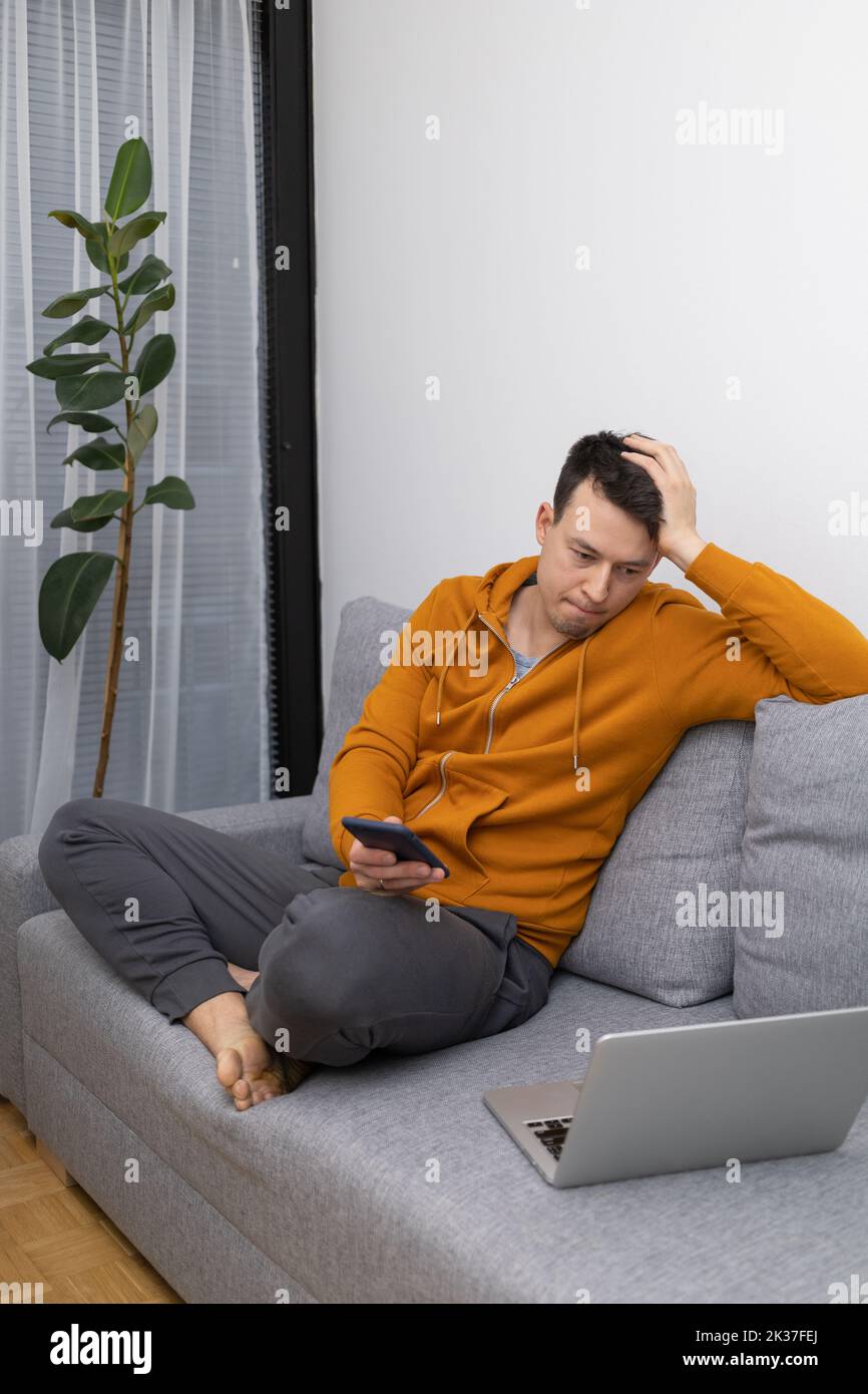 hombre joven mirando al teléfono móvil jugando Foto de stock