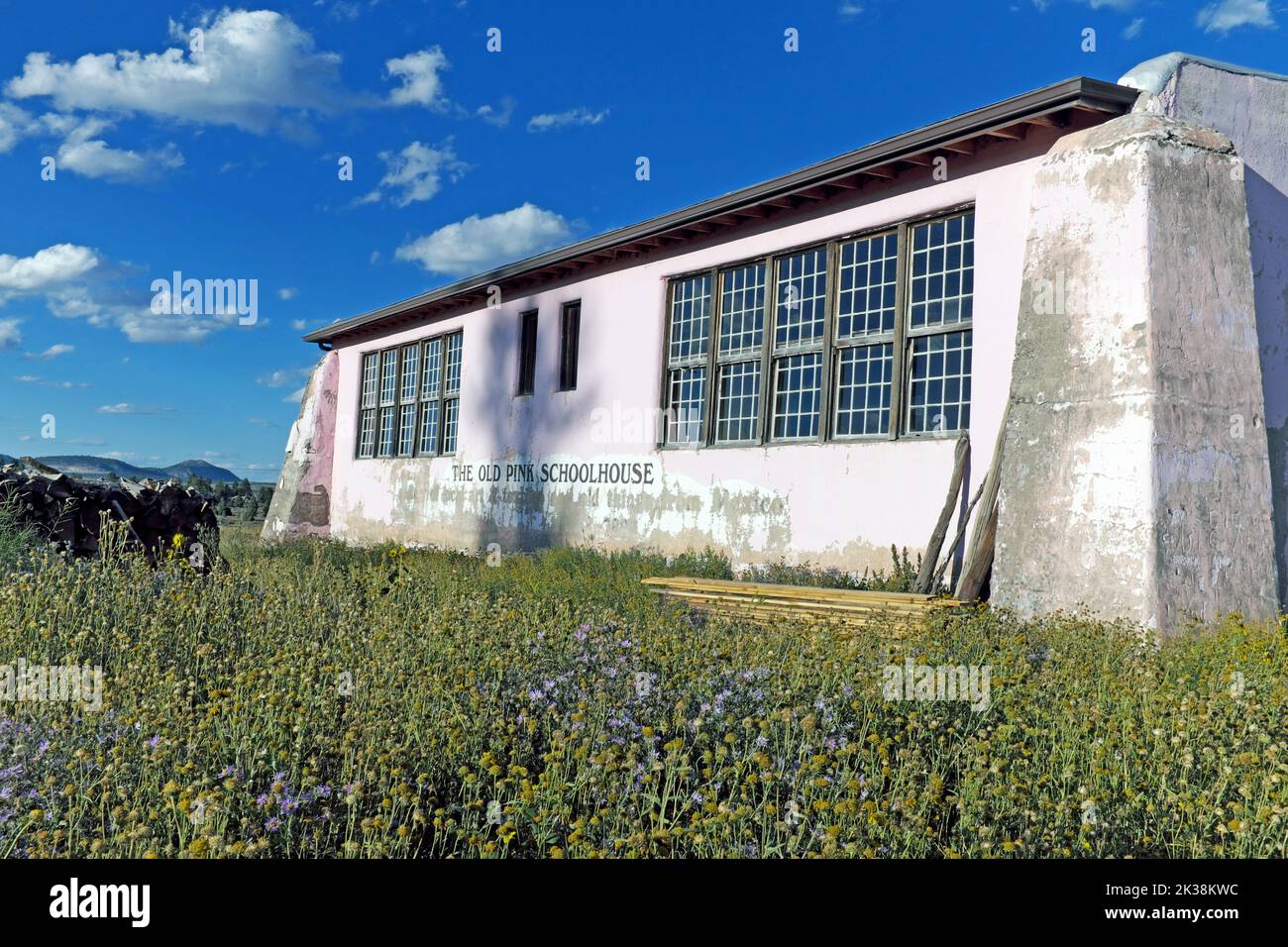 La antigua escuela Pink Schoolhouse, ubicada en el norte de Nuevo México en la pequeña ciudad de Tres Piedras, es una estructura icónica que ahora es una residencia privada. Foto de stock