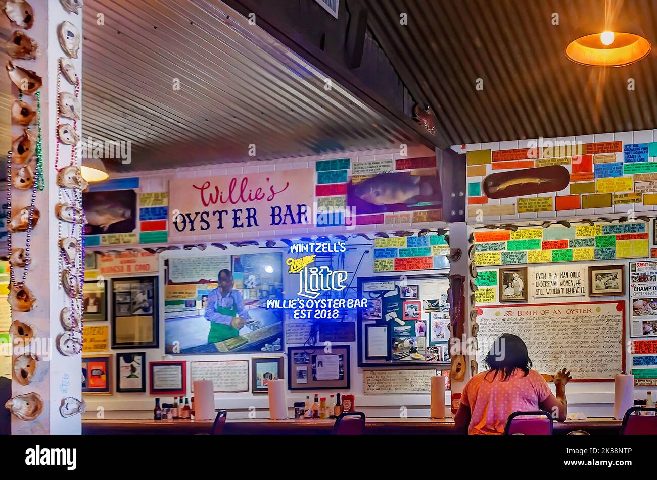 Un turista se sienta en el bar de ostras en Wintzell's Oyster House en Dauphin Street, el 24 de septiembre de 2022, en Mobile, Alabama. Wintzell’s fue fundada en 1938. Foto de stock