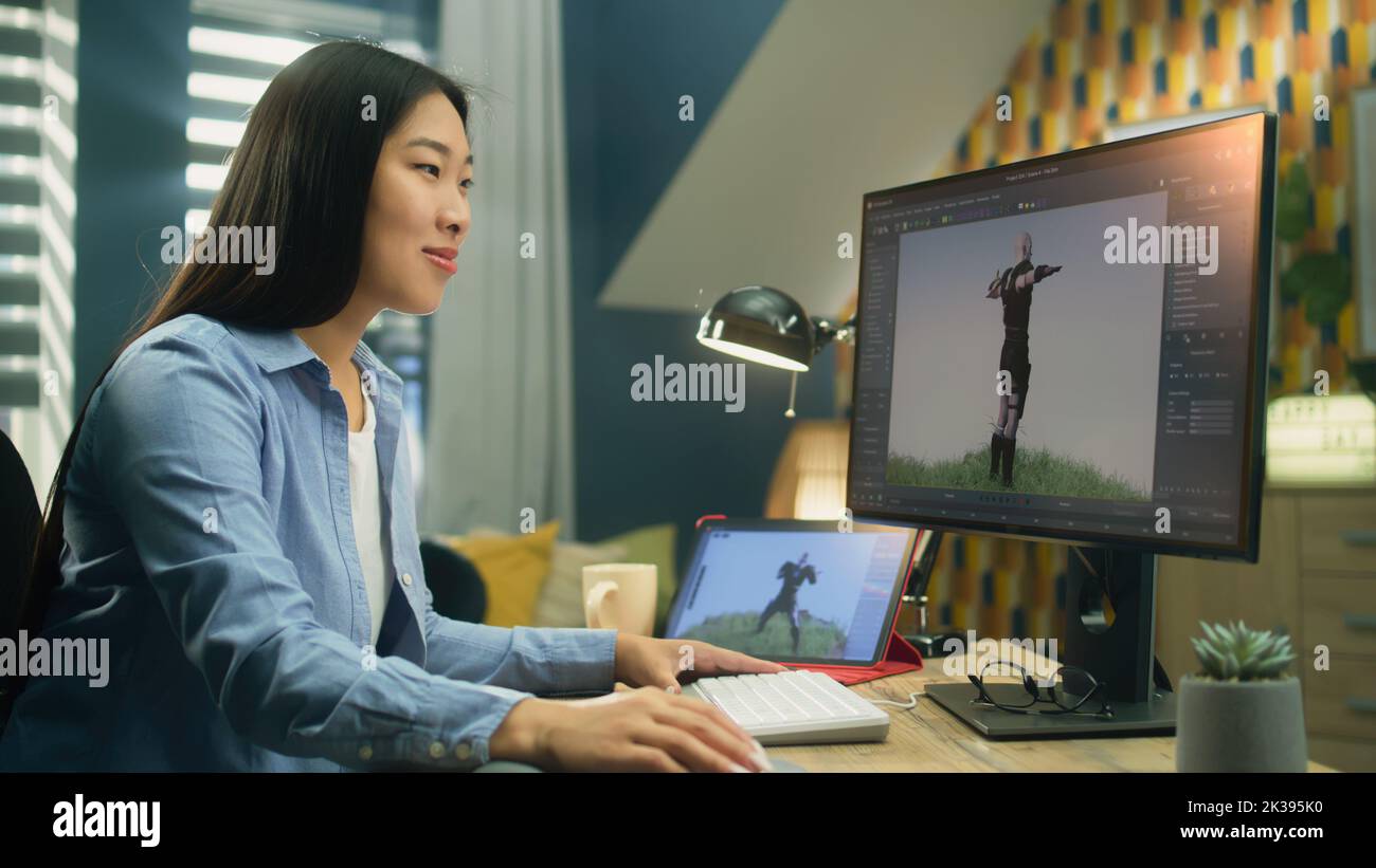 Diseñadora 3D asiática haciendo animación para el personaje de videojuegos utilizando un ordenador moderno y una tableta y un software para la creación de proyectos de modelado en 3D Foto de stock