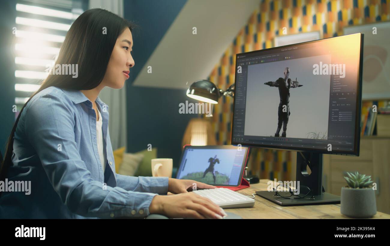 Diseñadora 3D asiática haciendo animación para el personaje de videojuegos utilizando un ordenador moderno y una tableta y un software para la creación de proyectos de modelado en 3D Foto de stock