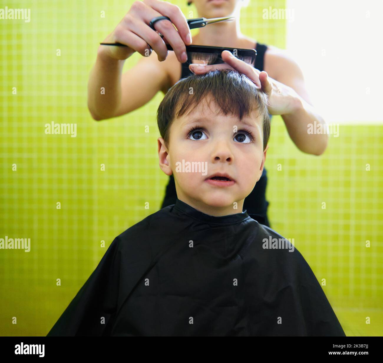 Esto no es tan malo... un chico joven que se corta el pelo. Foto de stock