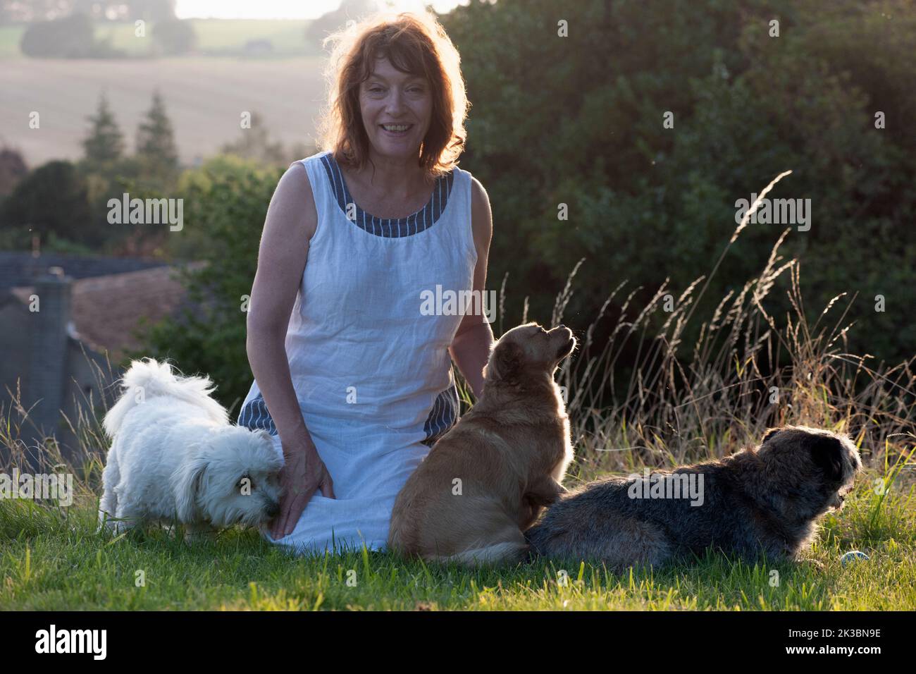 Mujer sonriendo con tres perros Foto de stock