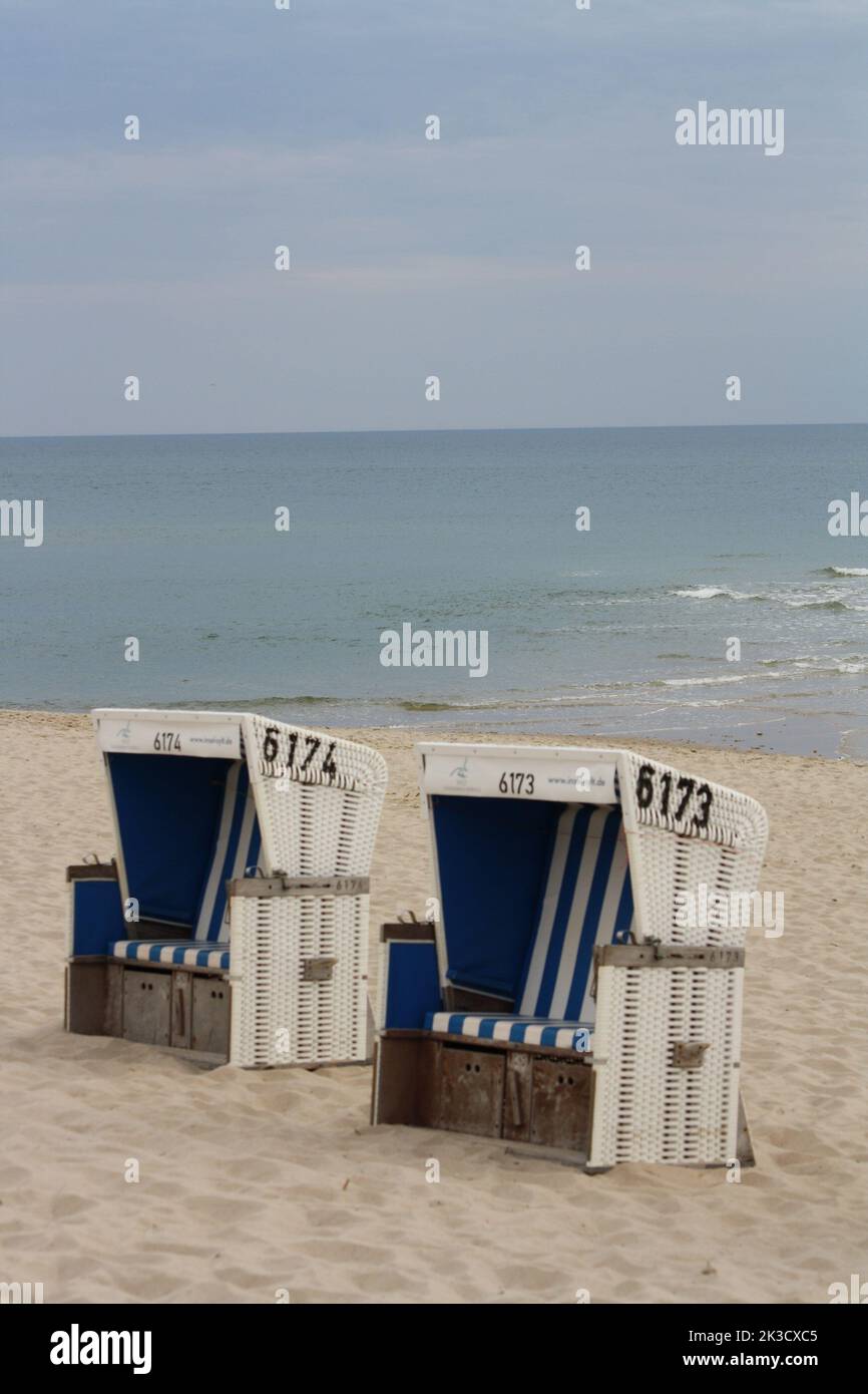 Sillas de mimbre con techo azul y blanco en la playa de Rantum en la isla de Sylt Foto de stock