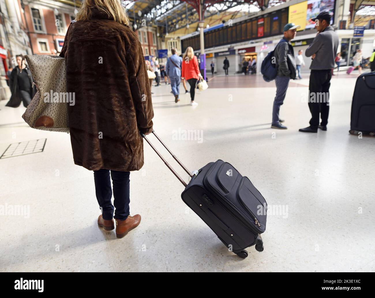 Londres, Inglaterra, Reino Unido. Victoria Station - Mujer con equipaje Foto de stock