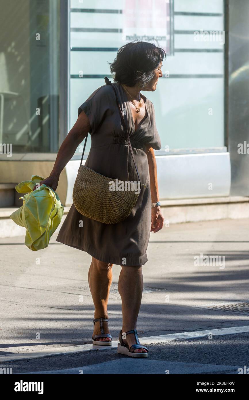 Mujer francesa madura saliendo del pavimento para cruzar la carretera - Chatellerault, Vienne (86), Francia. Foto de stock