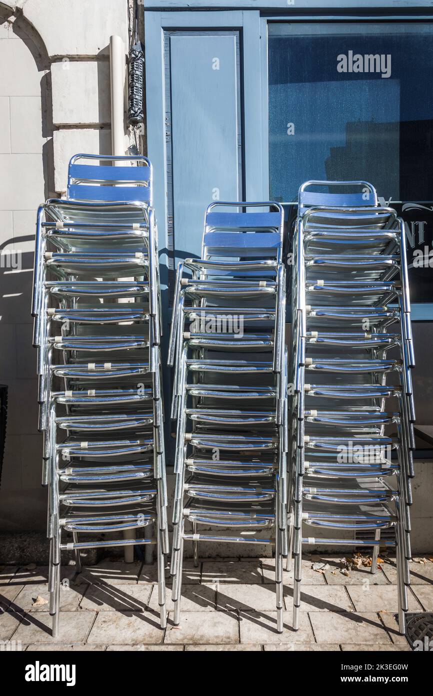Pilas de sillas de metal fuera restaurante - Chatellerault, Vienne (86), Francia. Foto de stock