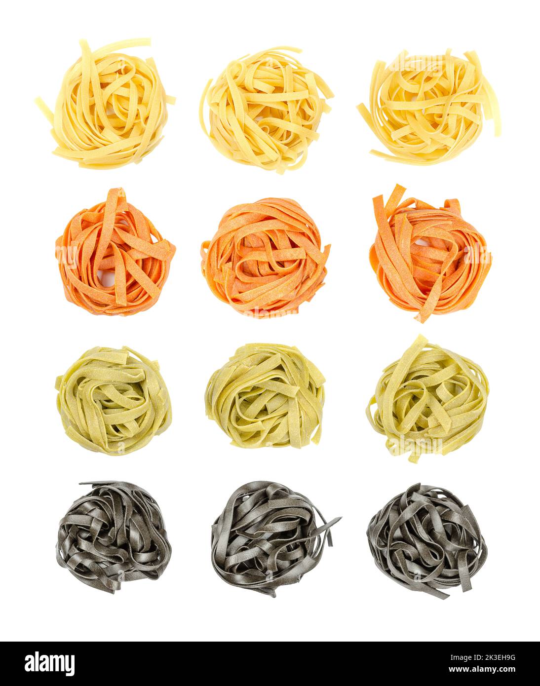Pasta tagliatelle coloreada, retorcida en nidos, desde arriba, aislada sobre blanco. Cuatro filas de pasta tradicional italiana sin cocinar y seca. Foto de stock