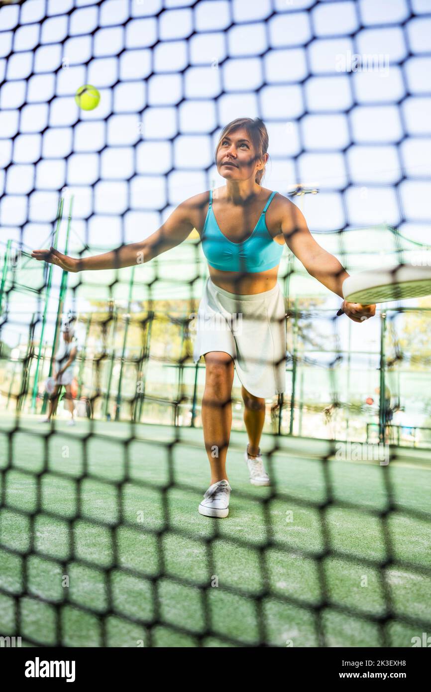 Mujer en pantalones cortos jugando tenis de pádel en la cancha Fotografía  de stock - Alamy