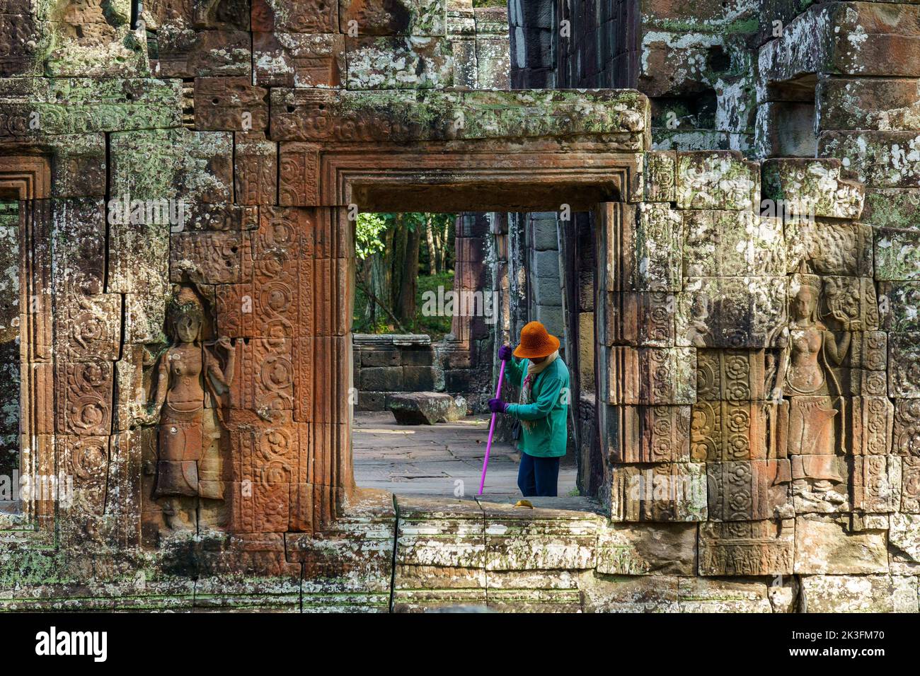 Camboya. Provincia de Siem Reap. El parque arqueológico de Angkor. Una mujer limpia las antiguas ruinas del templo Banteay Kdei Foto de stock