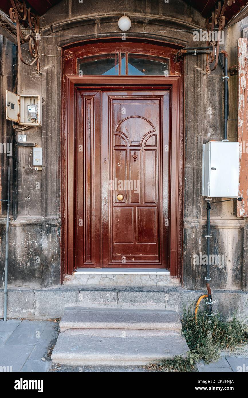 Antigua casa de piedra clásica con puerta rústica de madera tallada en color marrón. Texturas de puerta y fondo. Fotografía de alta calidad. Foto de stock