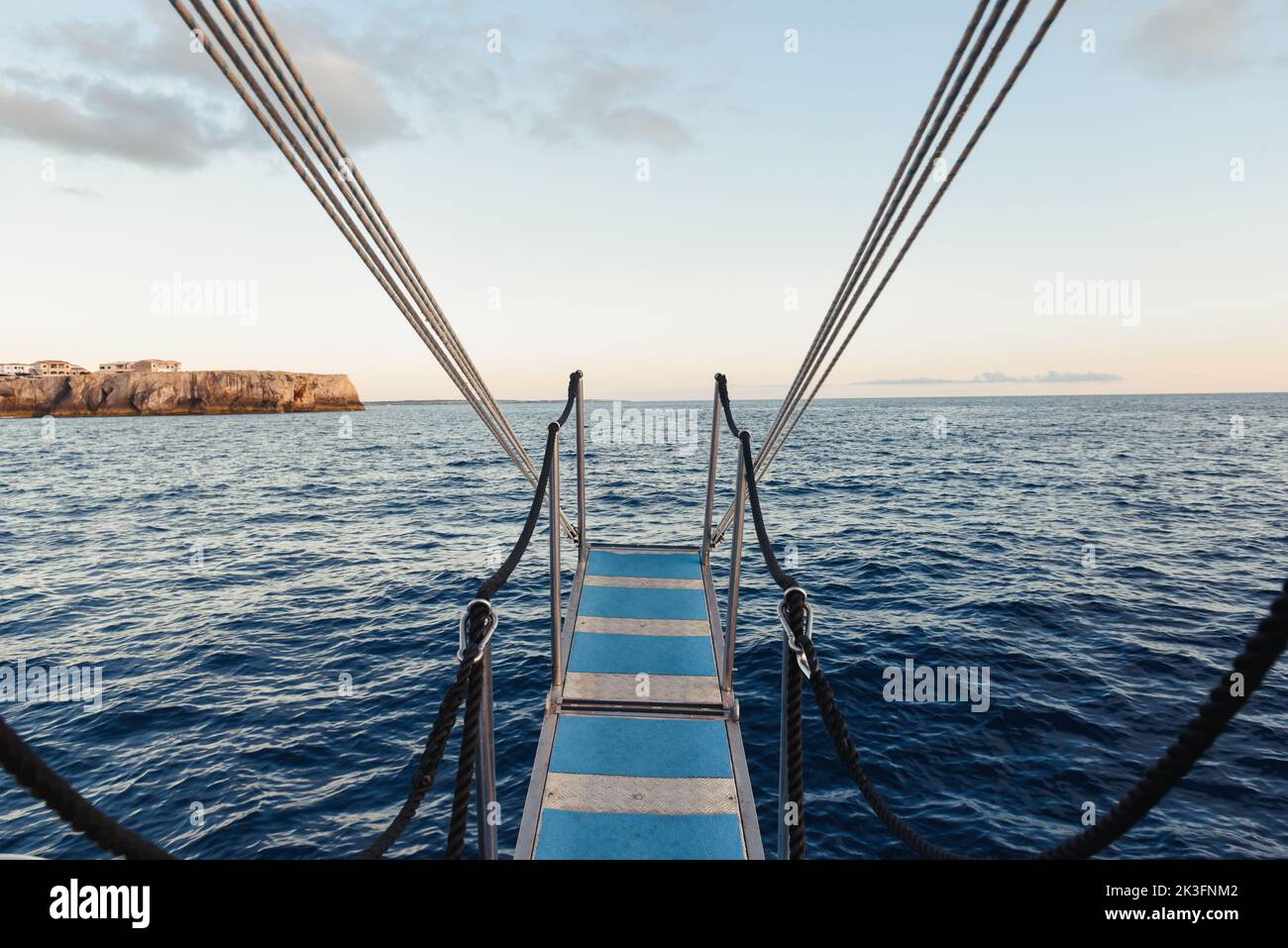 Vista desde un barco con escalera suspendida sobre el agua del océano Foto de stock