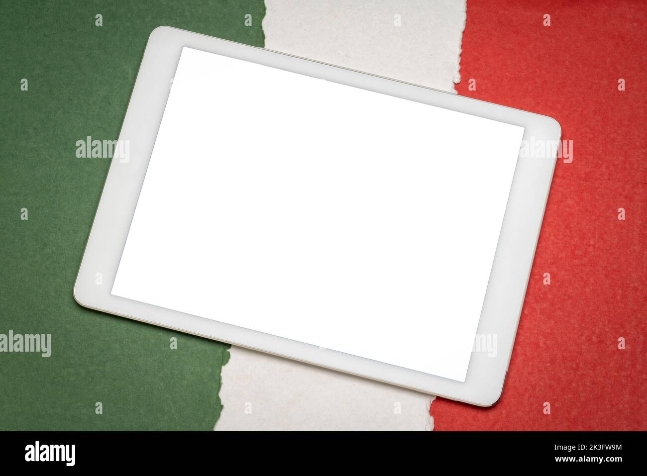 Maqueta de tableta digital con una pantalla aislada en blanco (ruta de recorte incluida) sobre papel abstracto en colores de la bandera nacional de Italia, verde, blanco A Foto de stock