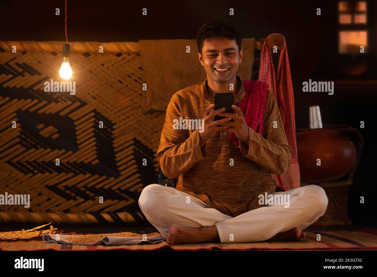 Retrato del hombre Bihar usando el teléfono móvil en casa Foto de stock