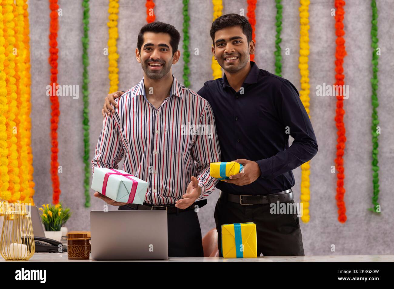 Compañeros de pie juntos en la oficina con regalos durante la celebración de Diwali Foto de stock