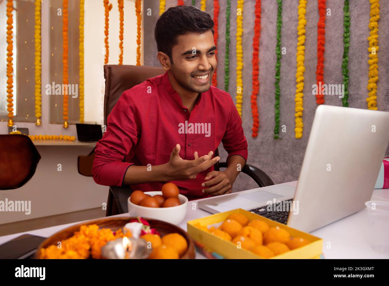Hombre haciendo videollamada en el portátil en la oficina durante la celebración de Diwali Foto de stock
