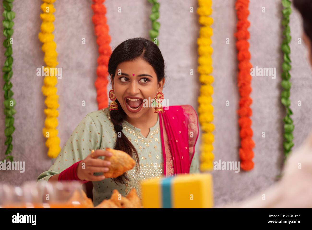 Mujer comiendo samosa en el cargo durante la celebración de Diwali Foto de stock