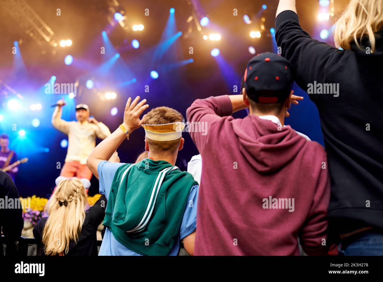 La energía es eléctrica. Imagen trasera de una multitud en un concierto con efectos de luz. Foto de stock