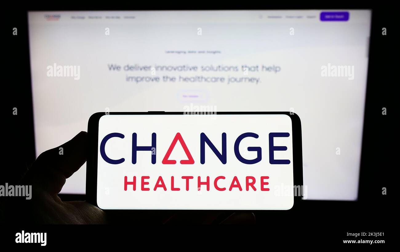 Persona con smartphone con el logotipo de la empresa estadounidense Change Healthcare Inc. En la pantalla delante del sitio web. Enfoque la pantalla del teléfono. Foto de stock