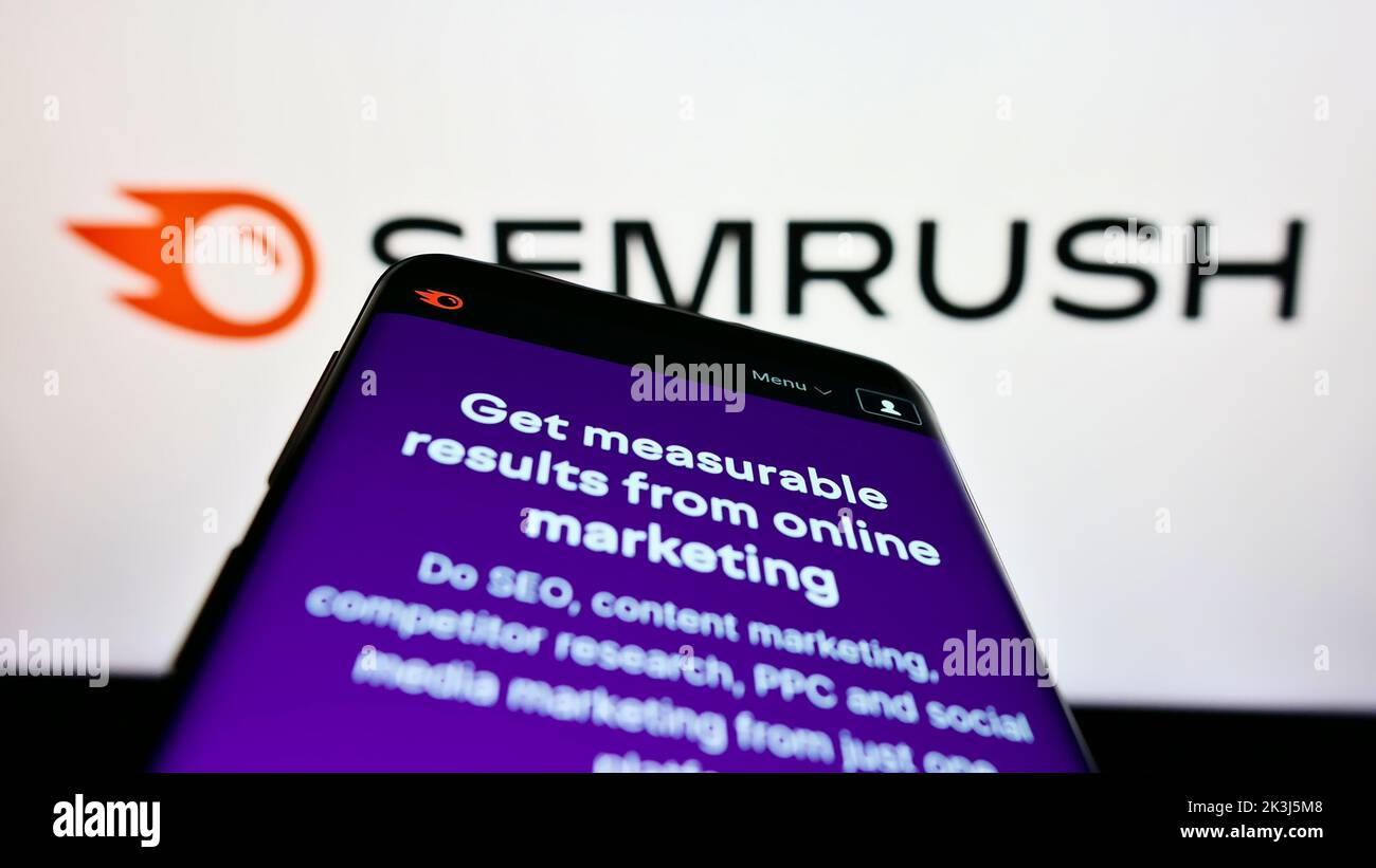 Teléfono móvil con el sitio web de la empresa estadounidense de marketing en motores de búsqueda SOMrush Inc. En la pantalla delante del logotipo. Enfoque en la parte superior izquierda de la pantalla del teléfono. Foto de stock