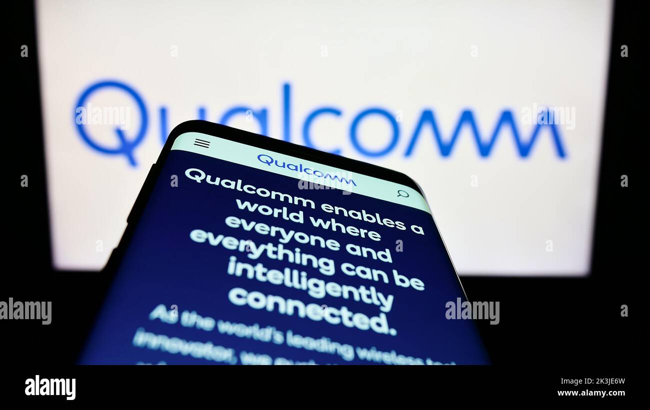 Teléfono móvil con sitio web de la empresa estadounidense de semiconductores Qualcomm Incorporated en la pantalla delante del logotipo. Enfoque en la parte superior izquierda de la pantalla del teléfono. Foto de stock