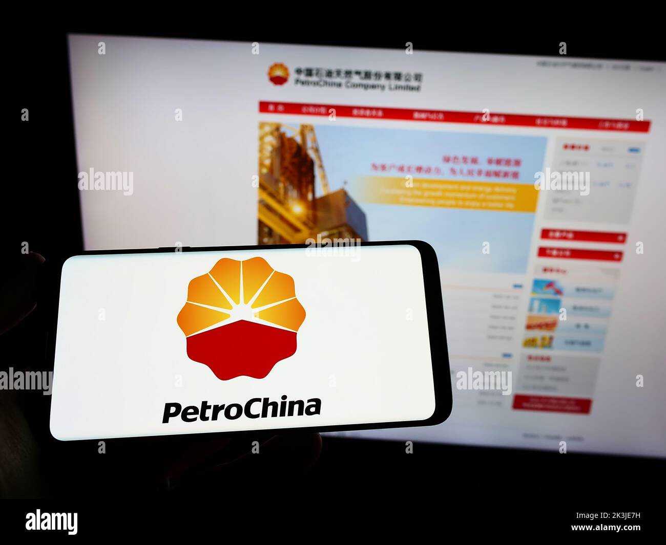 Persona que posee un smartphone con el logotipo de la compañía petrolera y de gas china PetroChina Company Limited en la pantalla delante del sitio web. Enfoque la pantalla del teléfono. Foto de stock