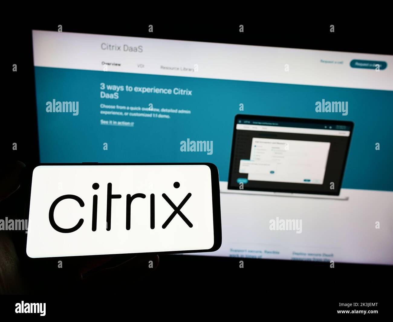 Persona que tiene un smartphone con el logotipo de la empresa de cloud computing de EE. UU. Citrix Systems Inc. En la pantalla delante del sitio web. Enfoque la pantalla del teléfono. Foto de stock