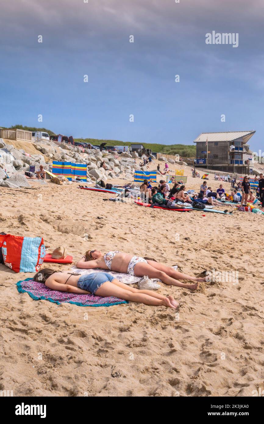 Turistas tomando el sol en una concurrida playa de Fistral en Newquay en Cornwall en el Reino Unido. Foto de stock