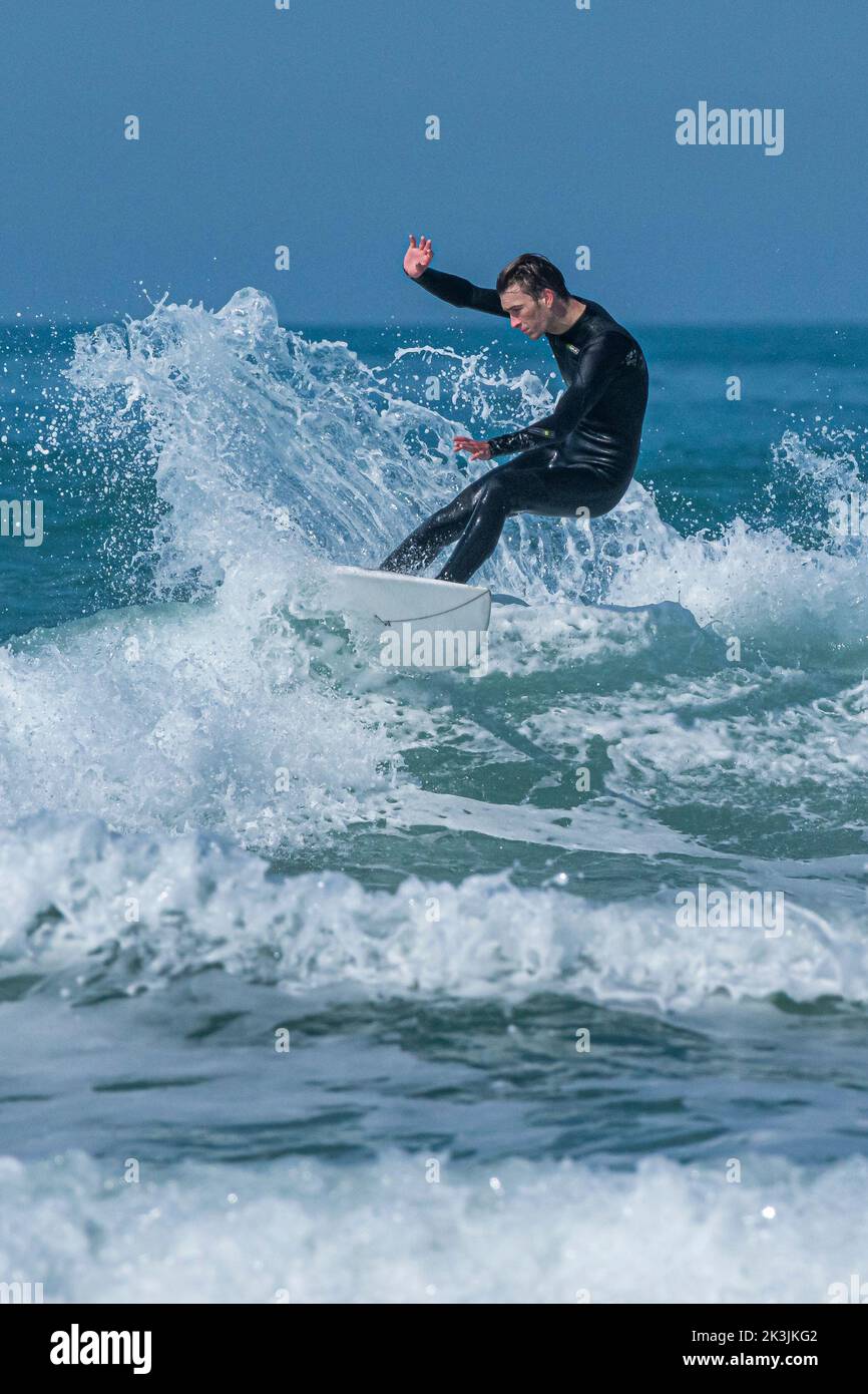 Espectacular acción surfear como surfista cabalga una ola en Fistral en Newquay en Cornwall en el Reino Unido. Foto de stock