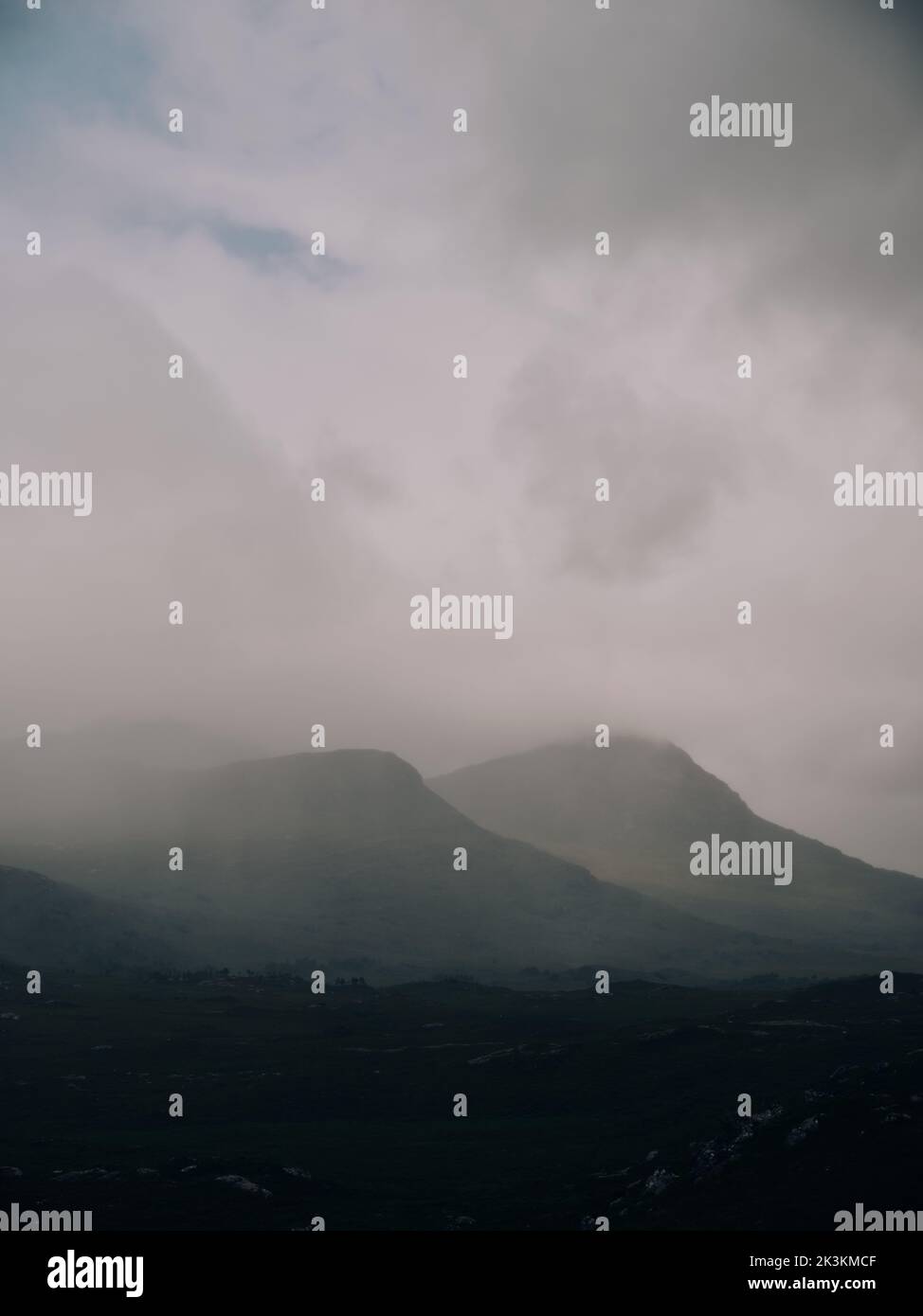 Un paisaje de montaña nublado, oscuro y árido, bajo nubes, en las Tierras Altas del Oeste de Escocia, Reino Unido - copia espacio Foto de stock