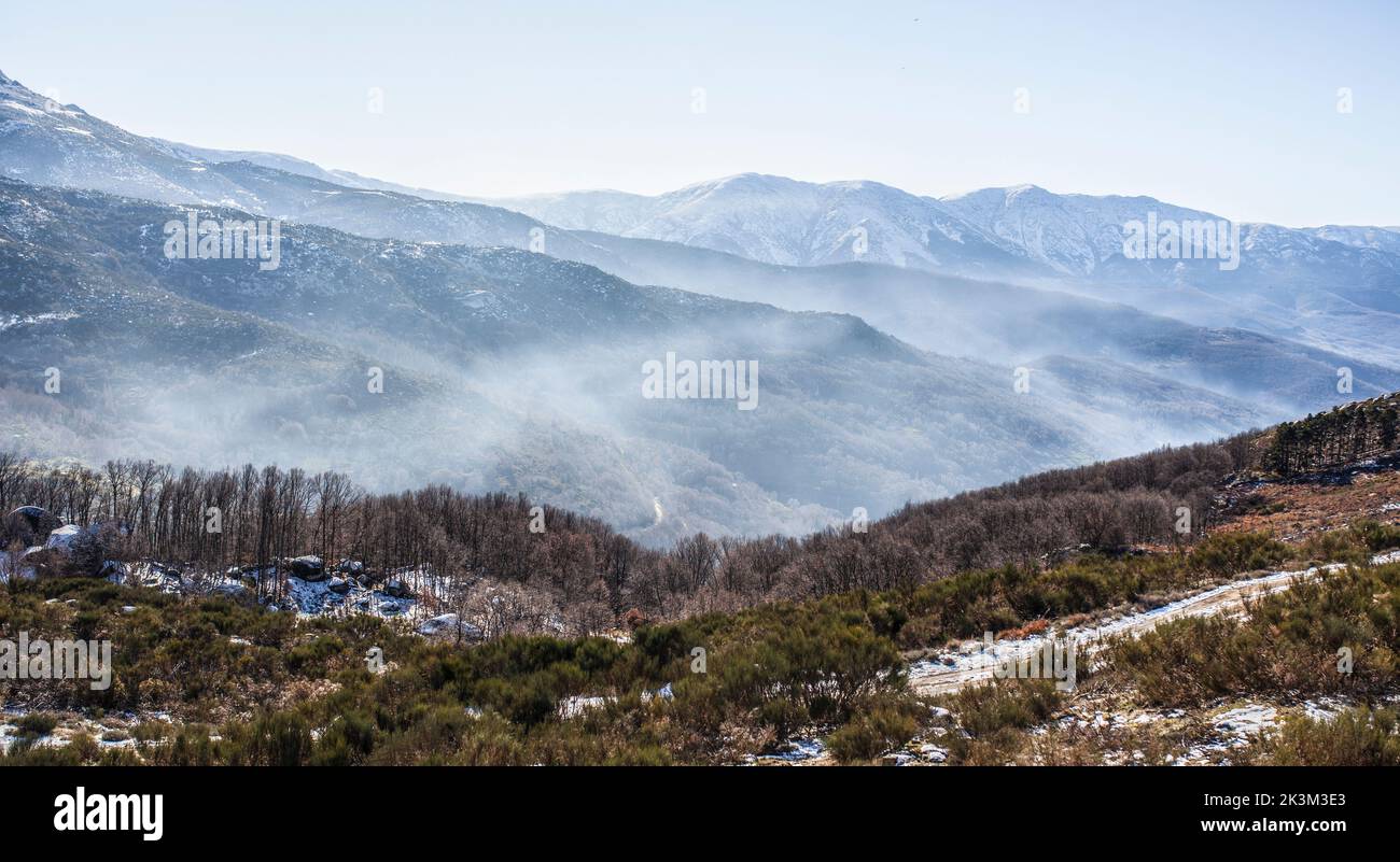 Niebla ambiental entre picos nevados de la Sierra de Gredos. La Garganta, Valle de Ambroz, Extremadura, Cáceres, España Foto de stock