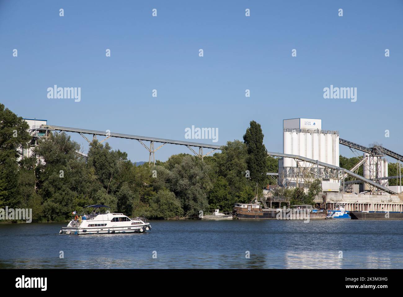 Barco en el río Saone Plattard Béton fábrica de cemento, Jassans-Riottier, Francia Foto de stock