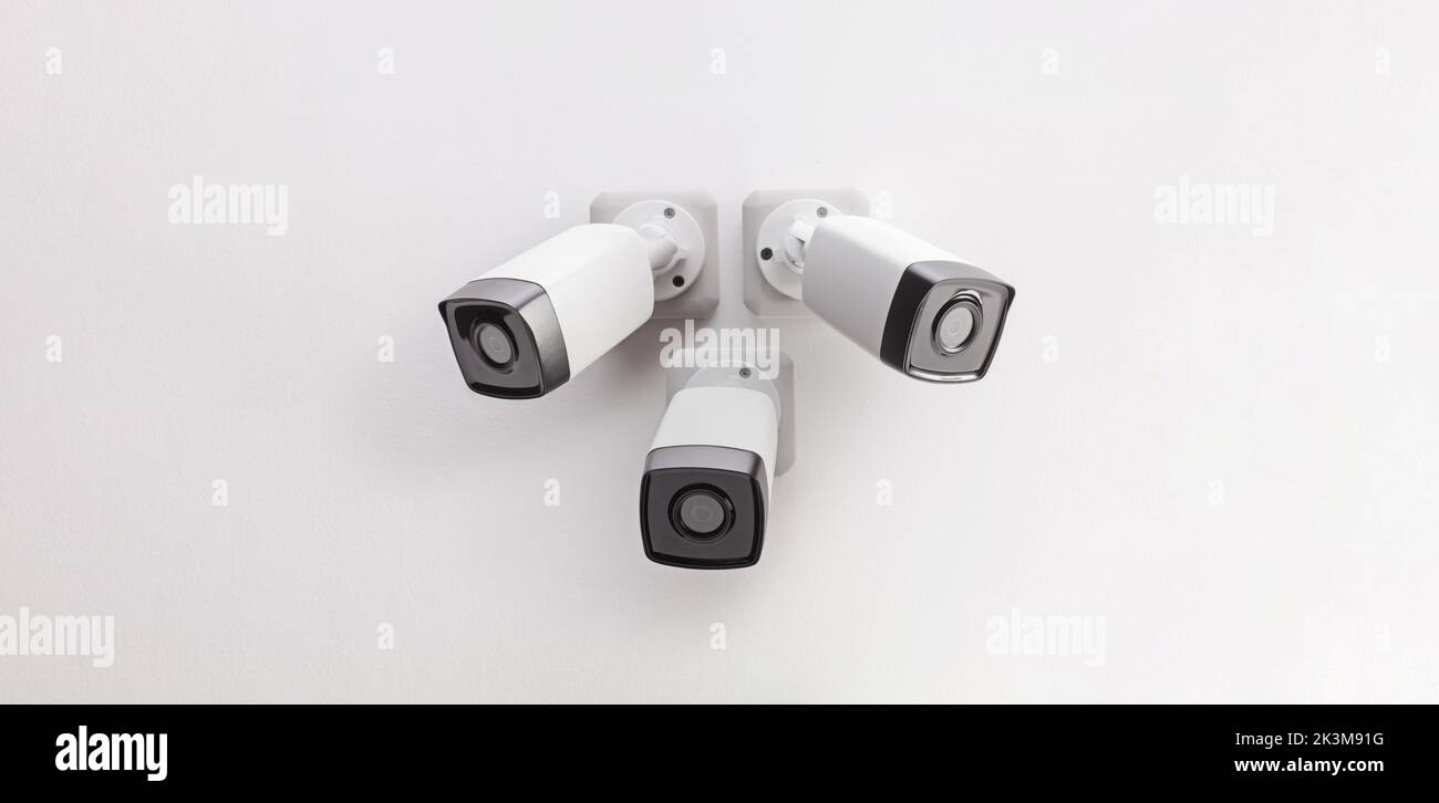 Tres cámaras de seguridad montadas en la pared Foto de stock