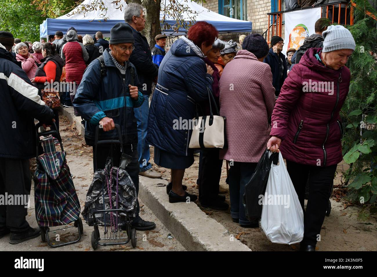 Kramatorsk, Donetsk, Ucrania. 26th de Sep de 2022. La gente espera recibir alimentos en un punto de distribución de ayuda humanitaria en Kramatorsk. En toda Ucrania, cerca de 580 asociados humanitarios han proporcionado ayuda vital y servicios de protección a 13,4 millones de personas. El presidente ucraniano Volodymyr Zelenskoy dijo que la región de Donetsk en el este seguía siendo la principal prioridad estratégica de su país -y de Rusia-, con combates que inundaban varias ciudades mientras las tropas rusas tratan de avanzar hacia el sur y el oeste. (Imagen de crédito: © Andriy Andriyenko/SOPA Images a través DE ZUMA Press Wire) Foto de stock