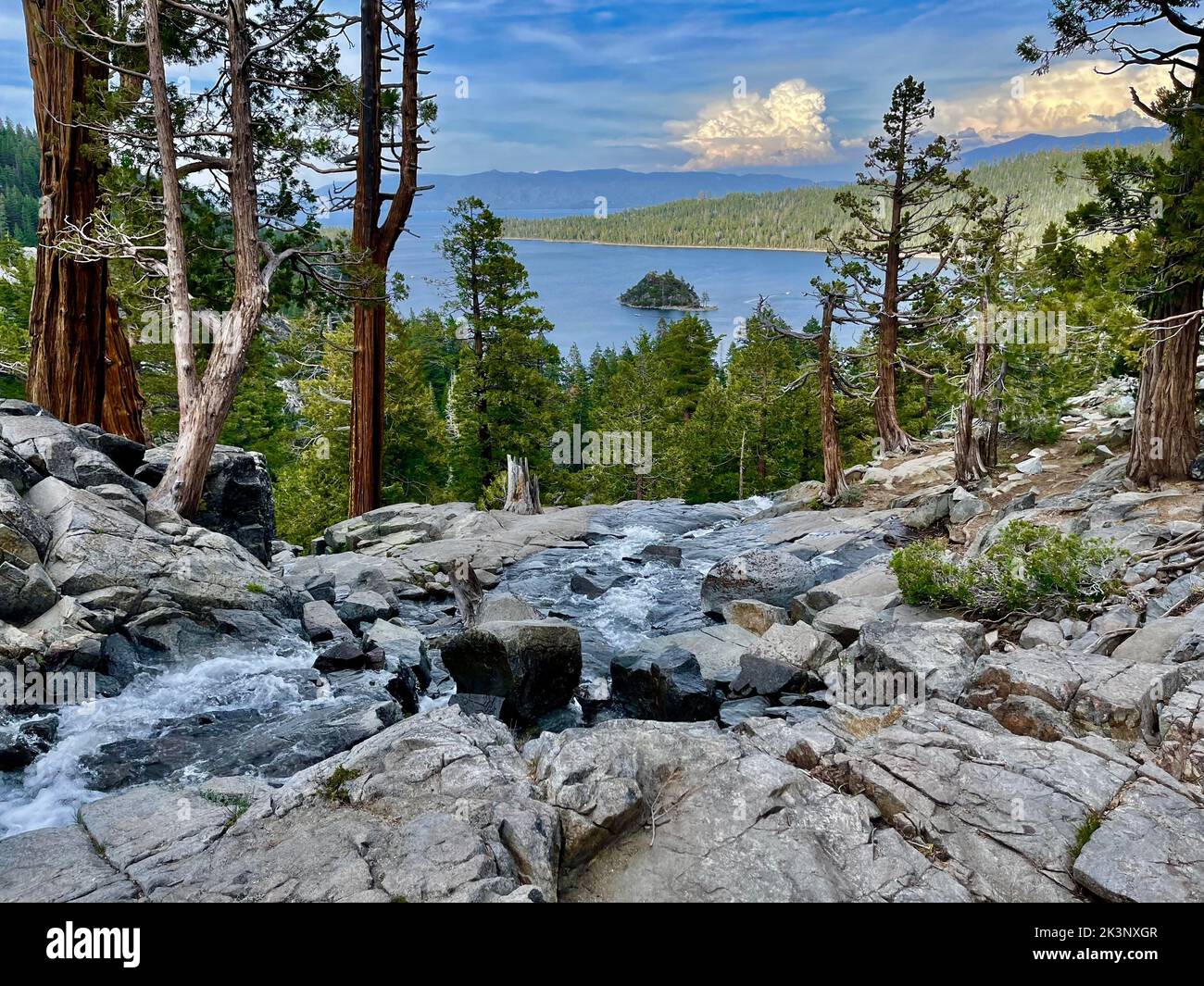 La hermosa vista de una cascada con un lago montañas en el fondo Foto de stock
