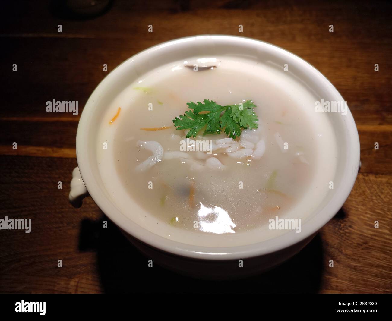 plato blanco de sopa de carne de pescado sobre la mesa de madera para comer Foto de stock
