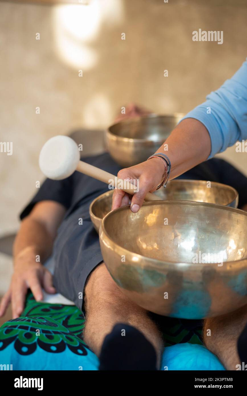 Terapia de campanas Tibetanas, cantando el tazón en las manos de un terapeuta Foto de stock