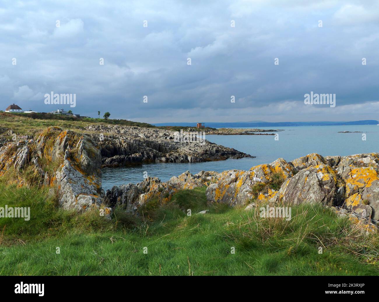 Belfast lough, en Irlanda del Norte, y el refugio abandonado en Orlock Point, en la costa de Co Down, visto a última hora de la tarde en suave estilo otoñal Foto de stock