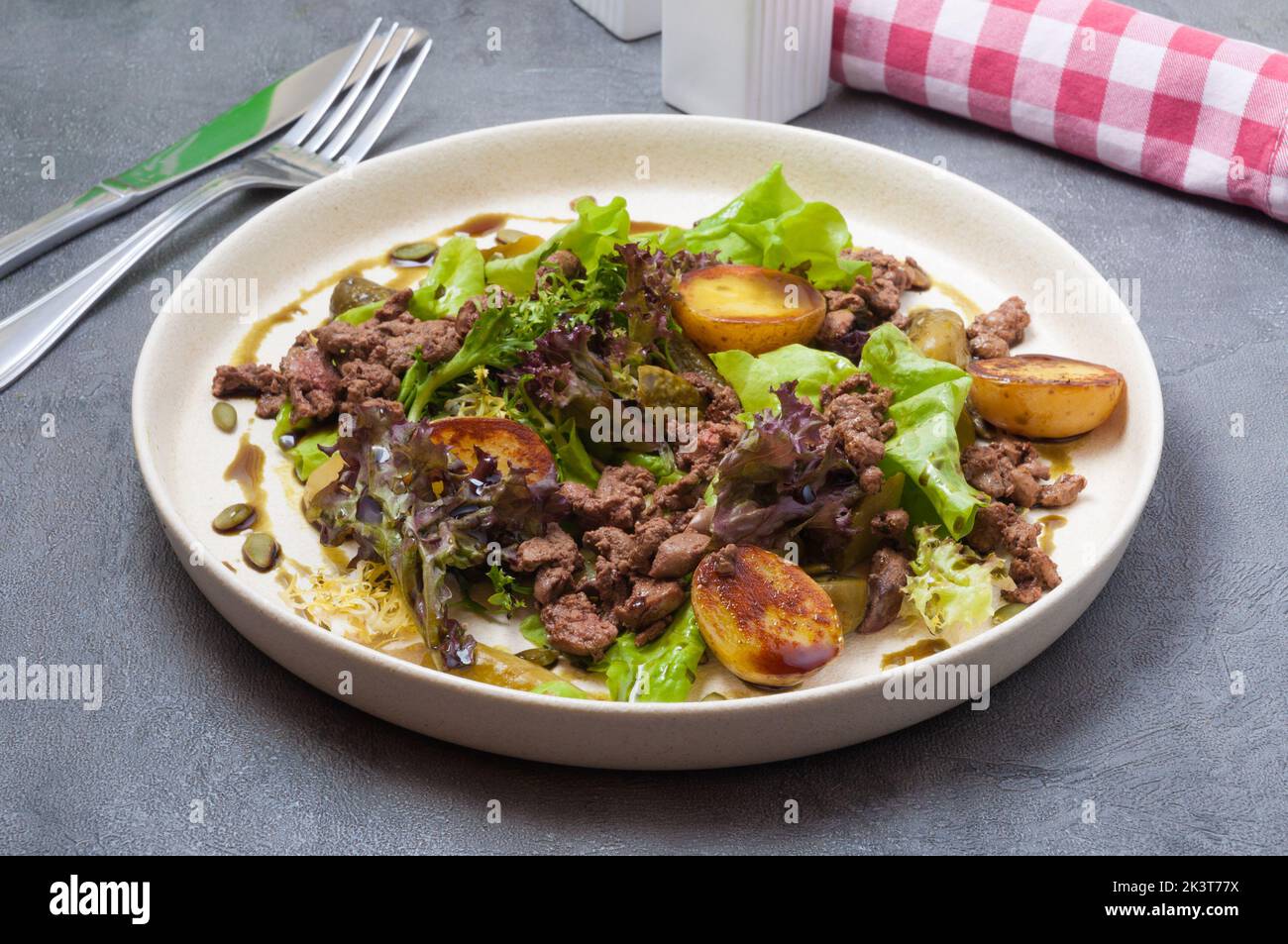 sabrosa ensalada caliente con patatas, hígado y pepino encurtido Foto de stock