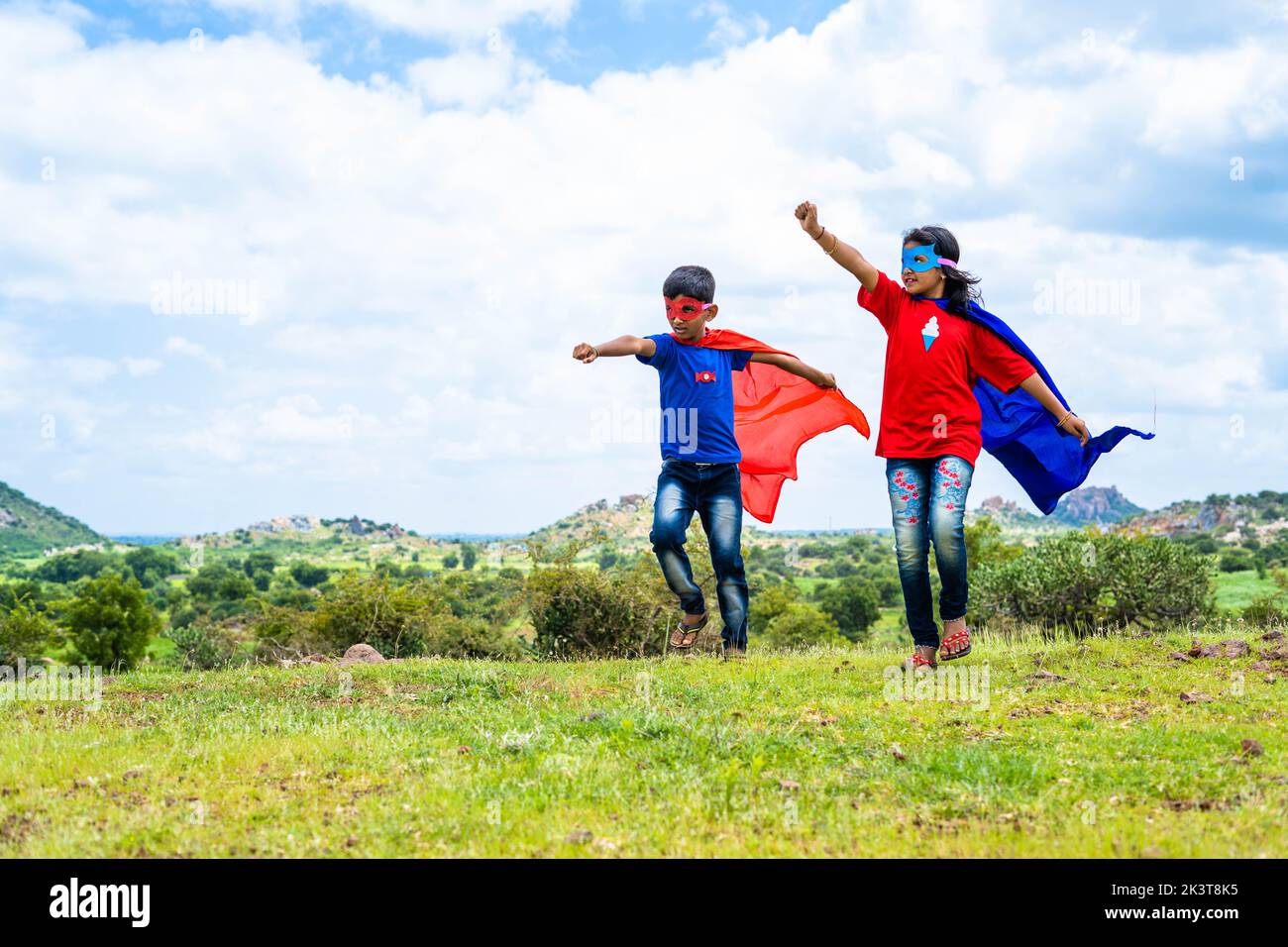 excitados adolescentes corriendo con disfraces de superhéroe en la cima de la montaña: concepto de estilo de vida infantil, inspiración y libertad. Foto de stock