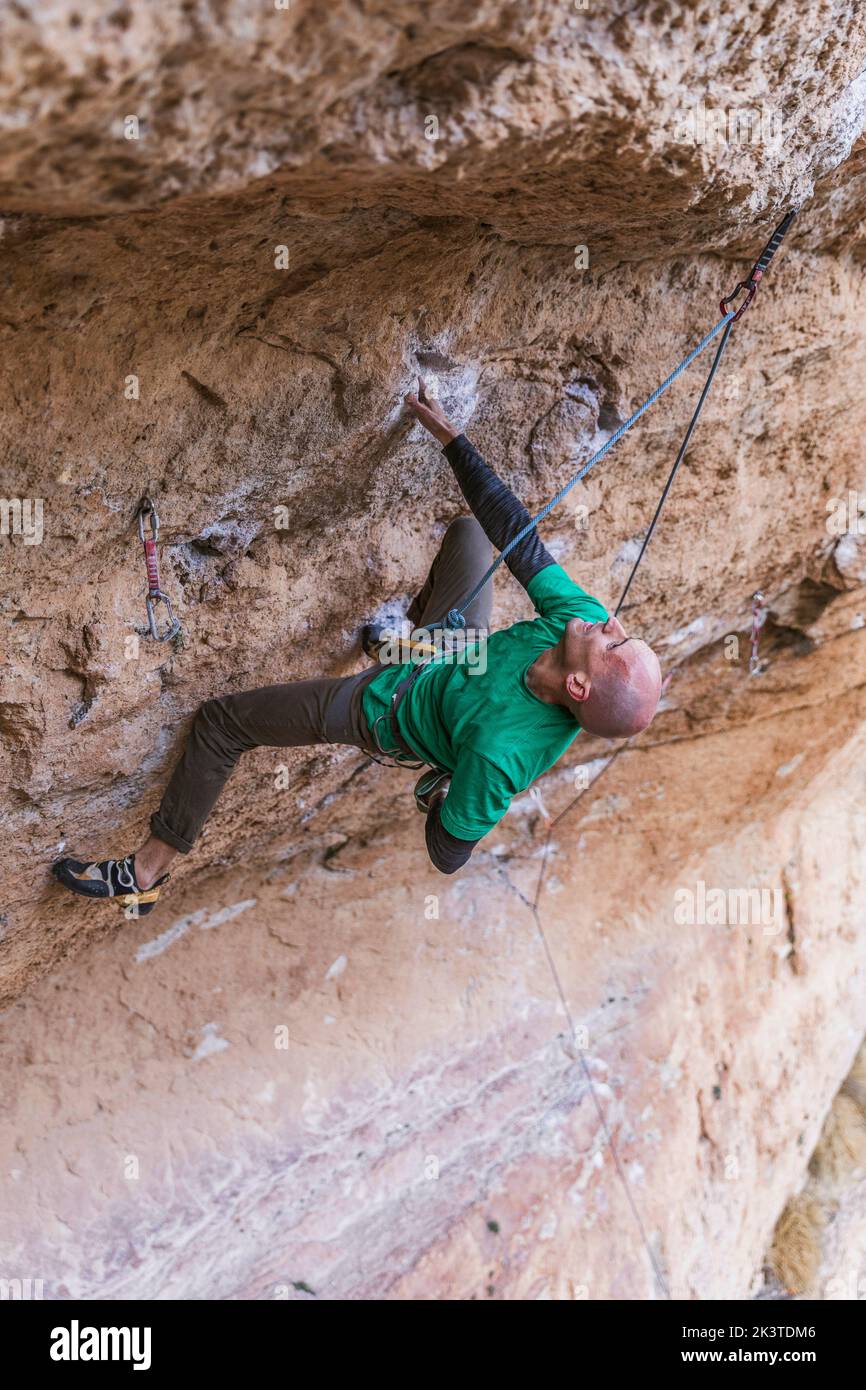 escalador colgando sobre cuerda en un acantilado accidentado Foto de stock