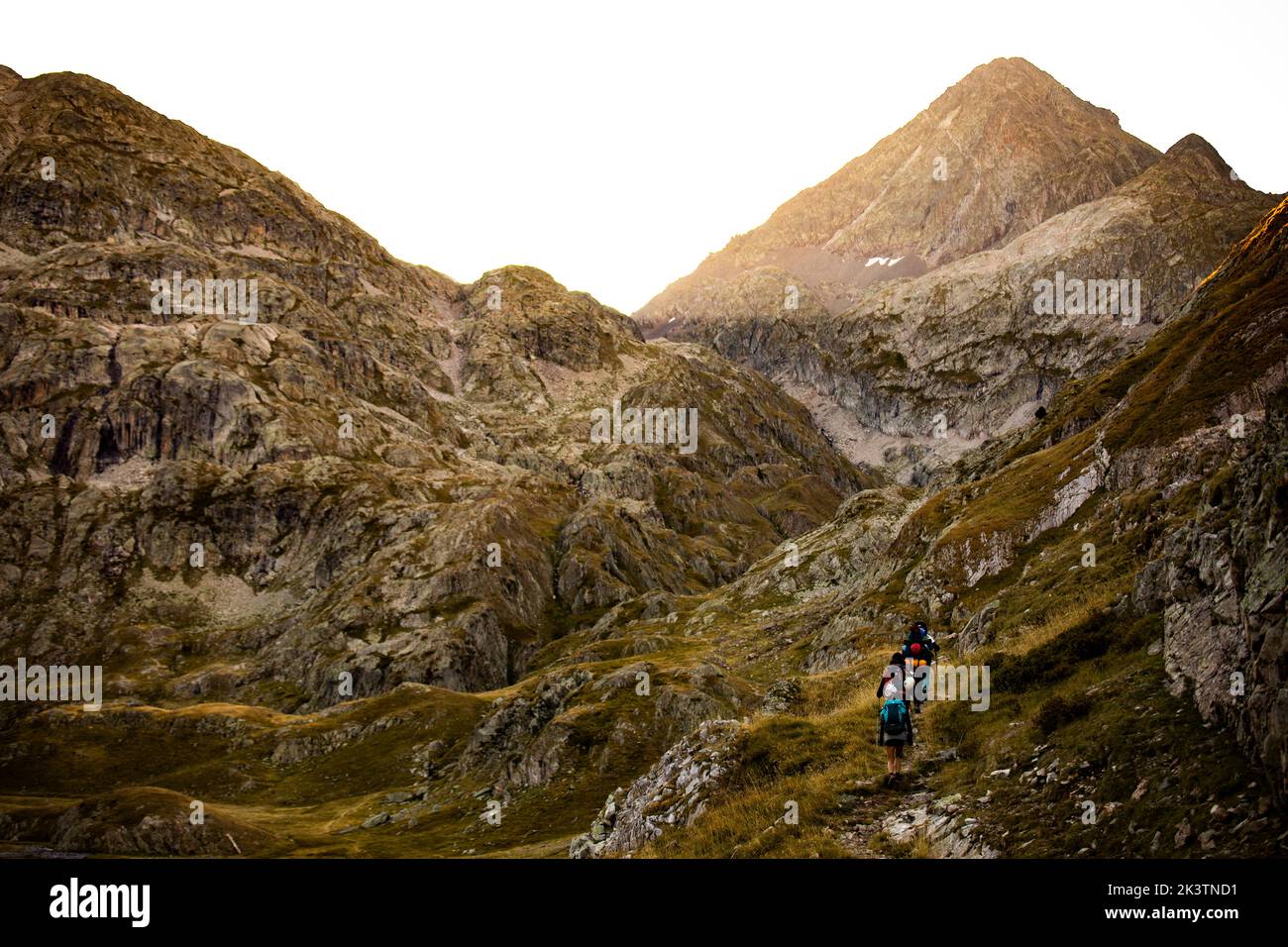 Grupo de montañeros con mochilas trepando pico rocoso en verano de aventura en los Pirineos Foto de stock
