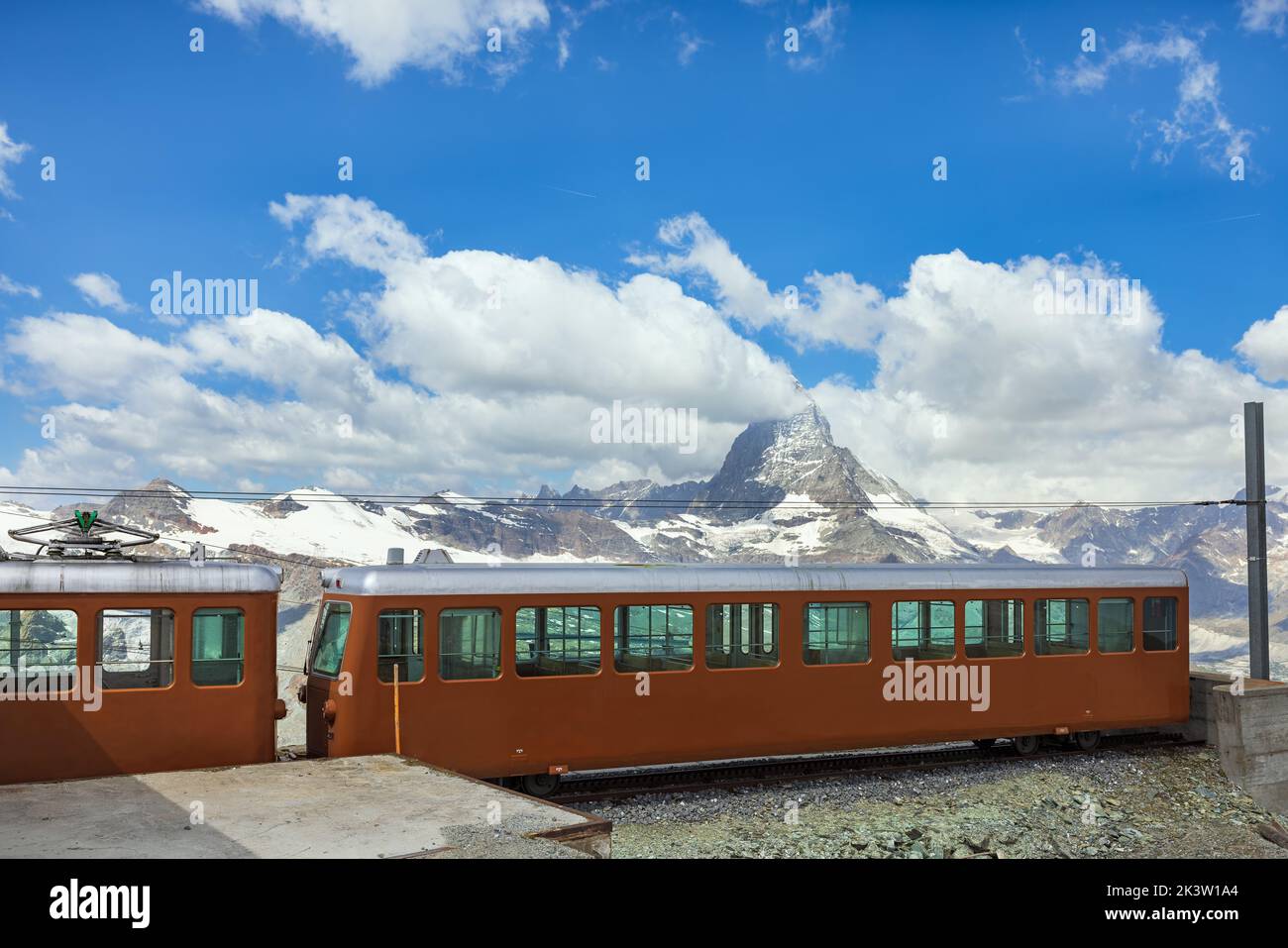 Tren rojo al fondo de la montaña Matterhorn en los Alpes suizos Foto de stock